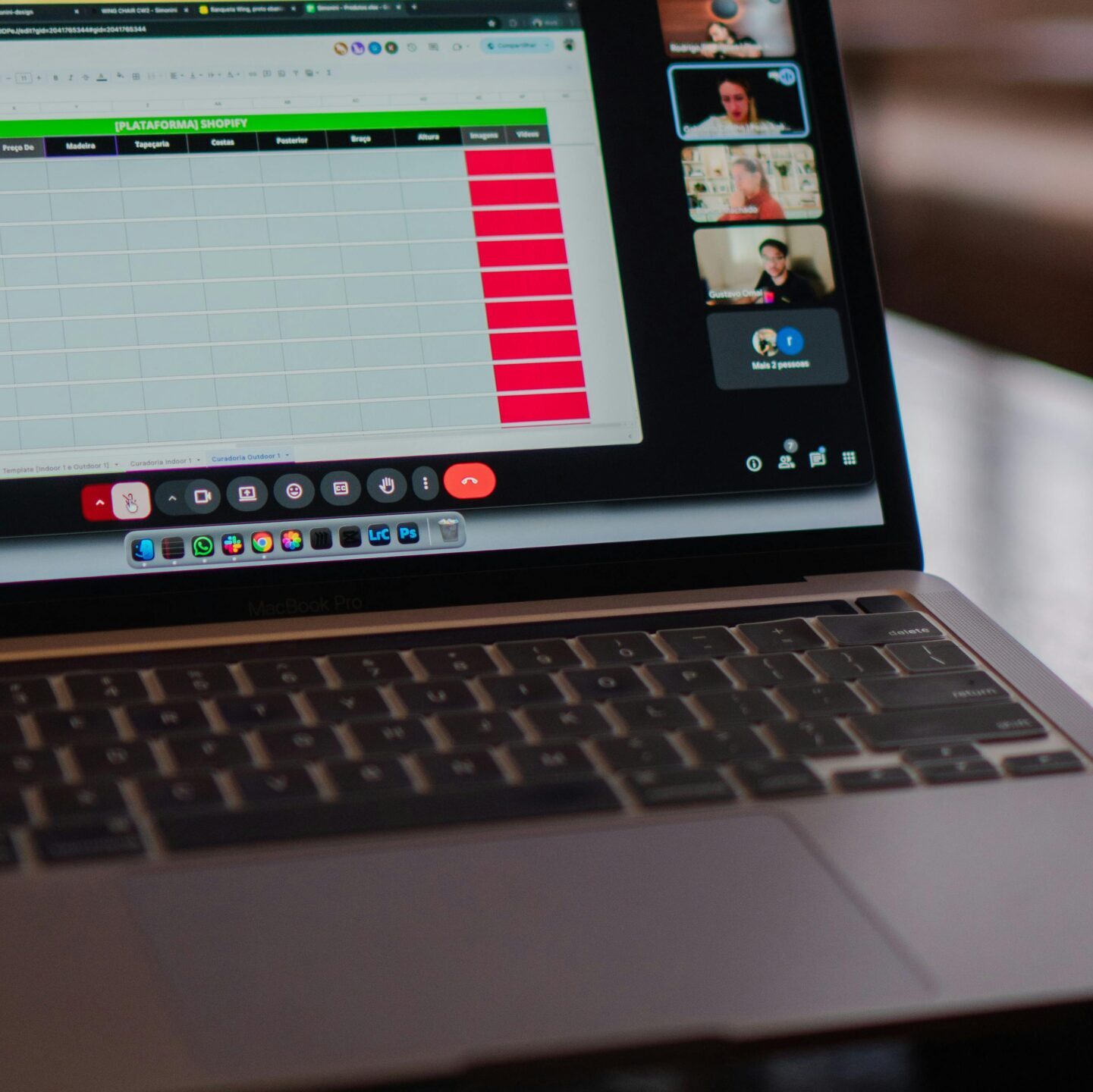 Laptop displaying a remote video meeting in a modern office setting.